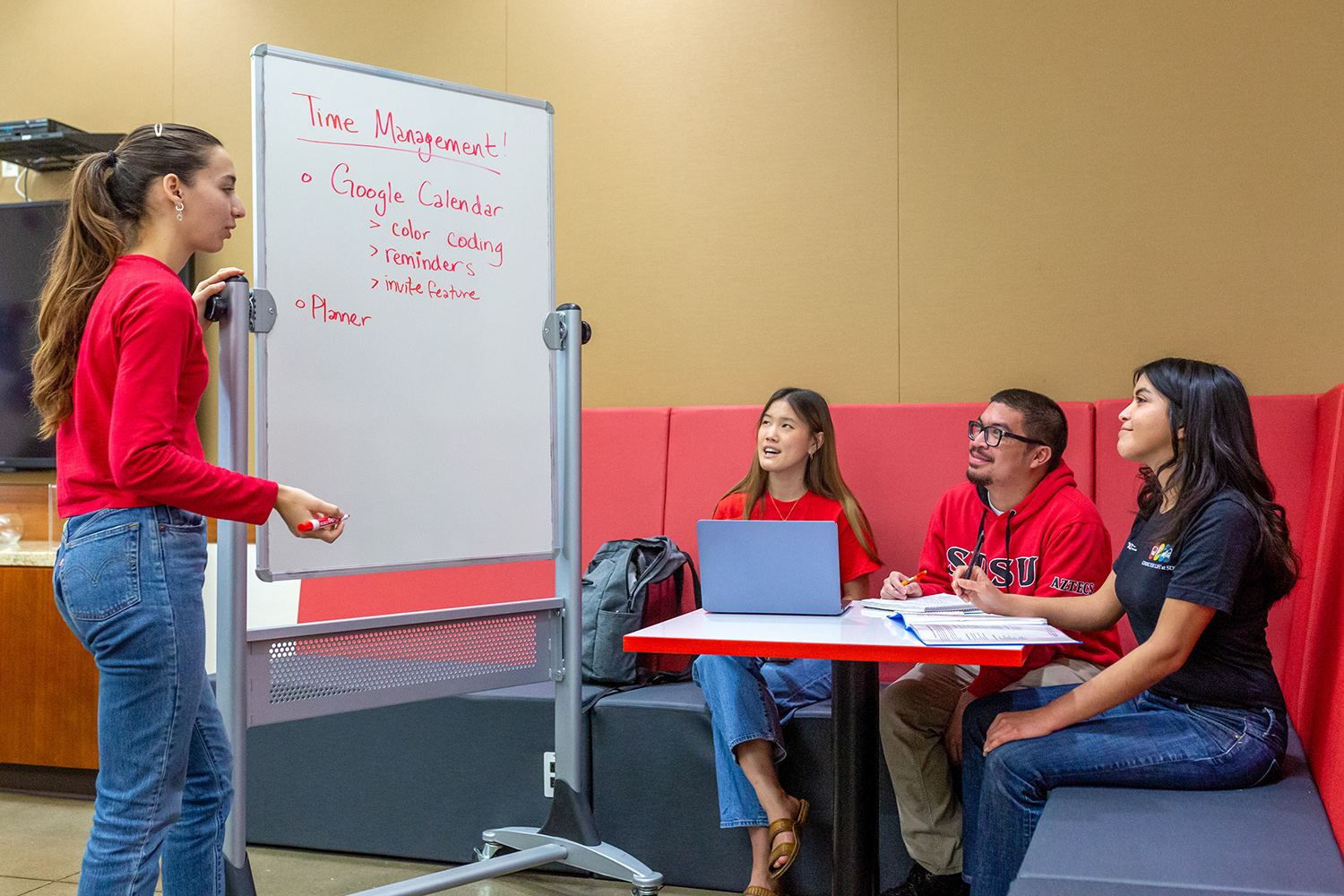 student speaking to group of three students sitting